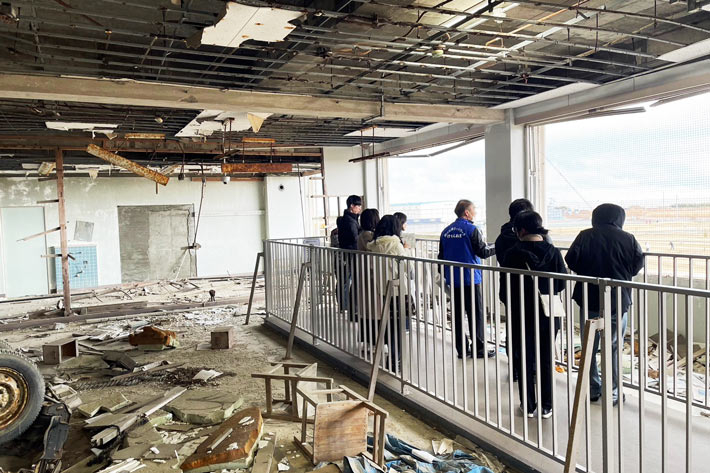 Participants listening to story of raconteur at remains of Kesennuma Koyo High School
