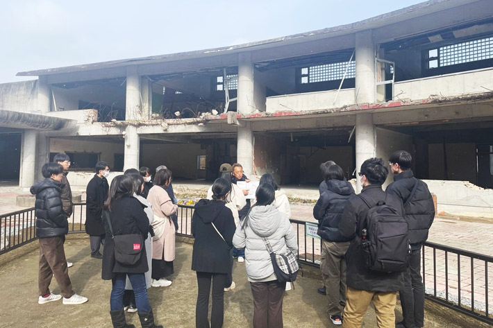 Participants at Ishinomaki City Okawa Elementary School Ruins with raconteur Suzuki