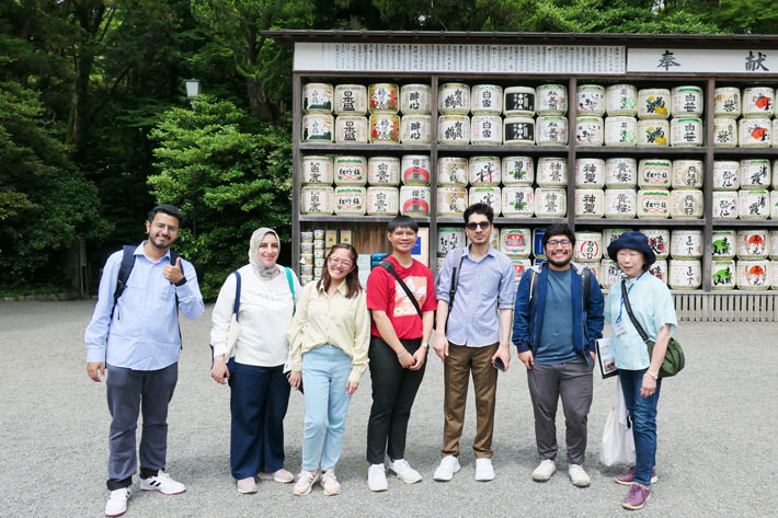 Group shot after listening to explanation of sake barrels dedicated to gods