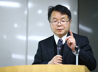 Hosono delivers a presentation.