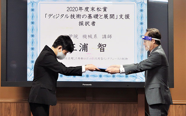 益学長(右)から賞状を受け取る三浦講師