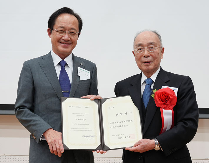 栄誉教授の称号記を手にする伊賀栄誉教授(右)と益学長