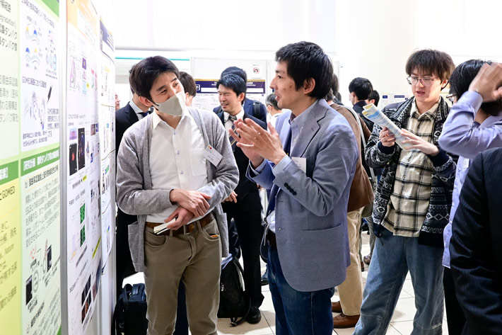 ポスターの前で議論する参加者