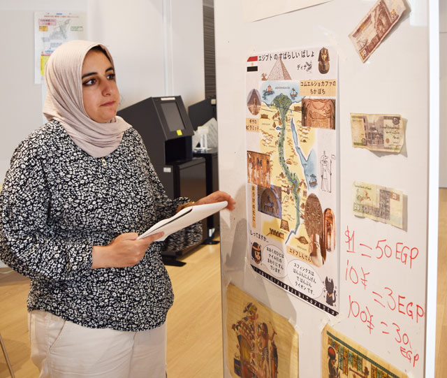 小学生を前に説明をする留学生